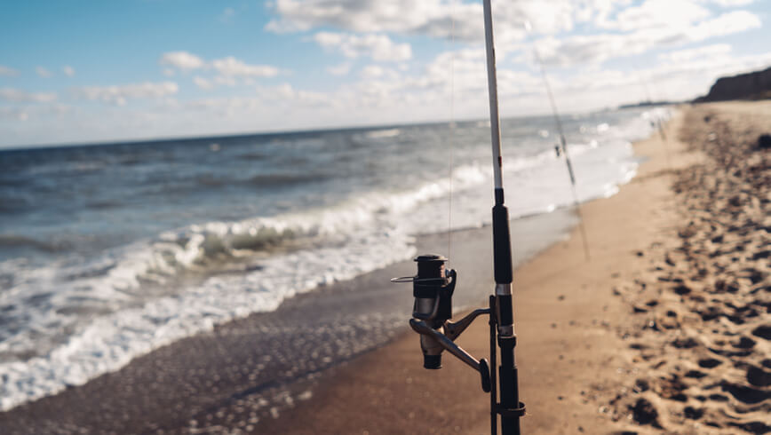 Fishermen put their fishing rods on the beach for surf fishing.